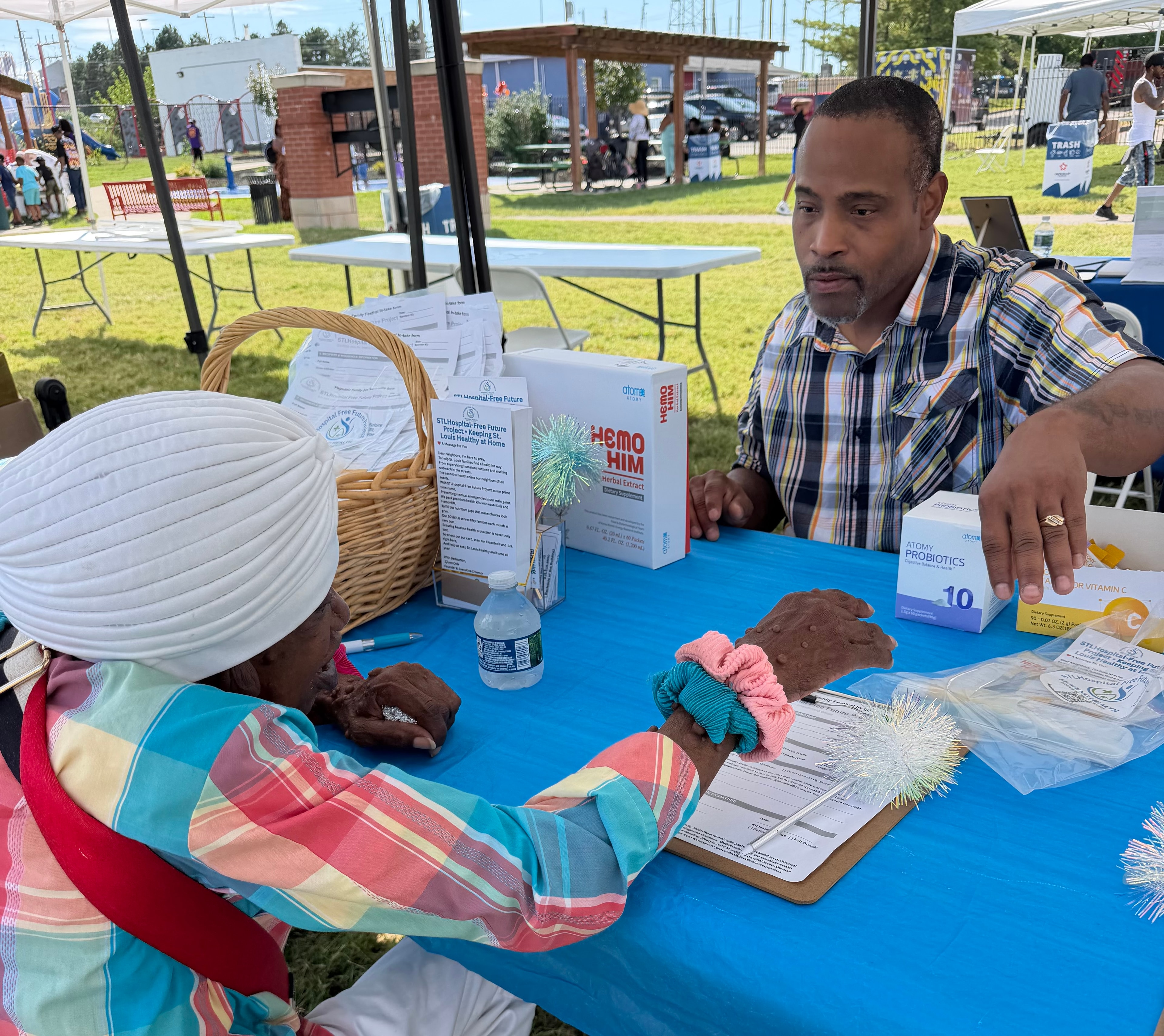 Henry McCoy speaking with a community member at the Pagedale Family Festival booth