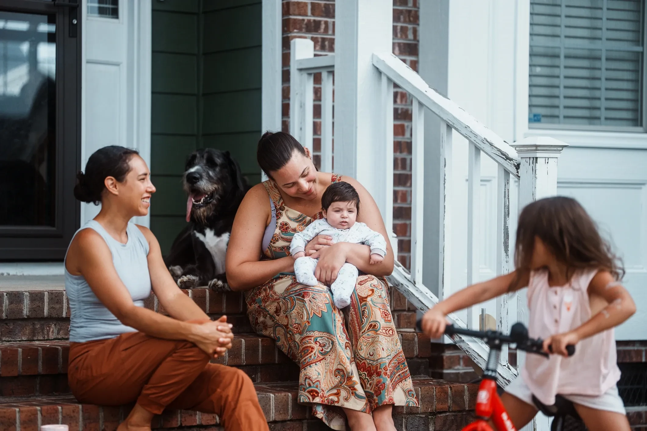 Family relaxing together on their front porch steps
